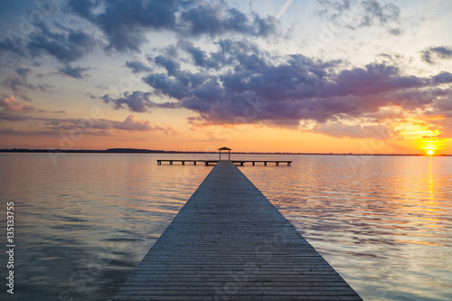 Fototapeta Naklejka Na Ścianę i Meble -  wooden pier overlooking the lake, the beautiful evening sky
