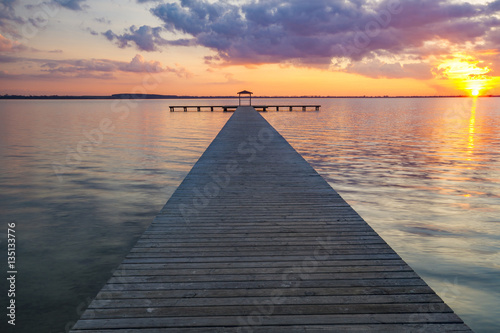 wooden pier overlooking the lake, the beautiful evening sky, colored by the setting sun 