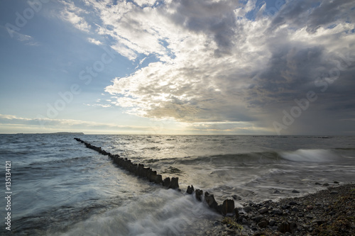 sea landscape, waves breaking on the breakwater pile of wood, baltic sea