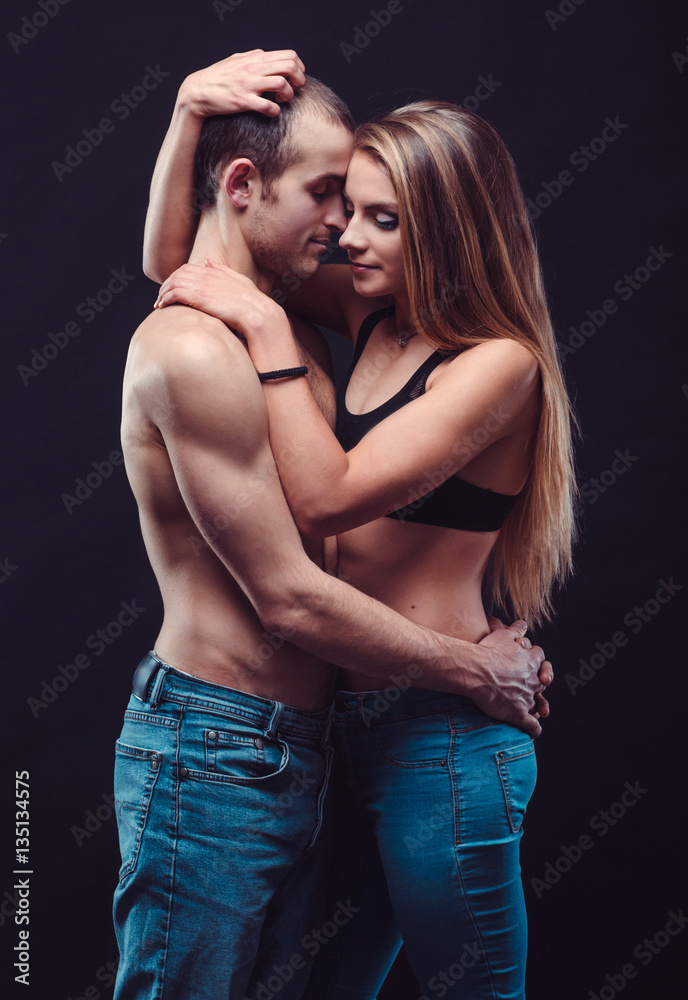 Sexy couple in jeans. Boyfriend and girlfriend embracing in the dark. foto  de Stock | Adobe Stock
