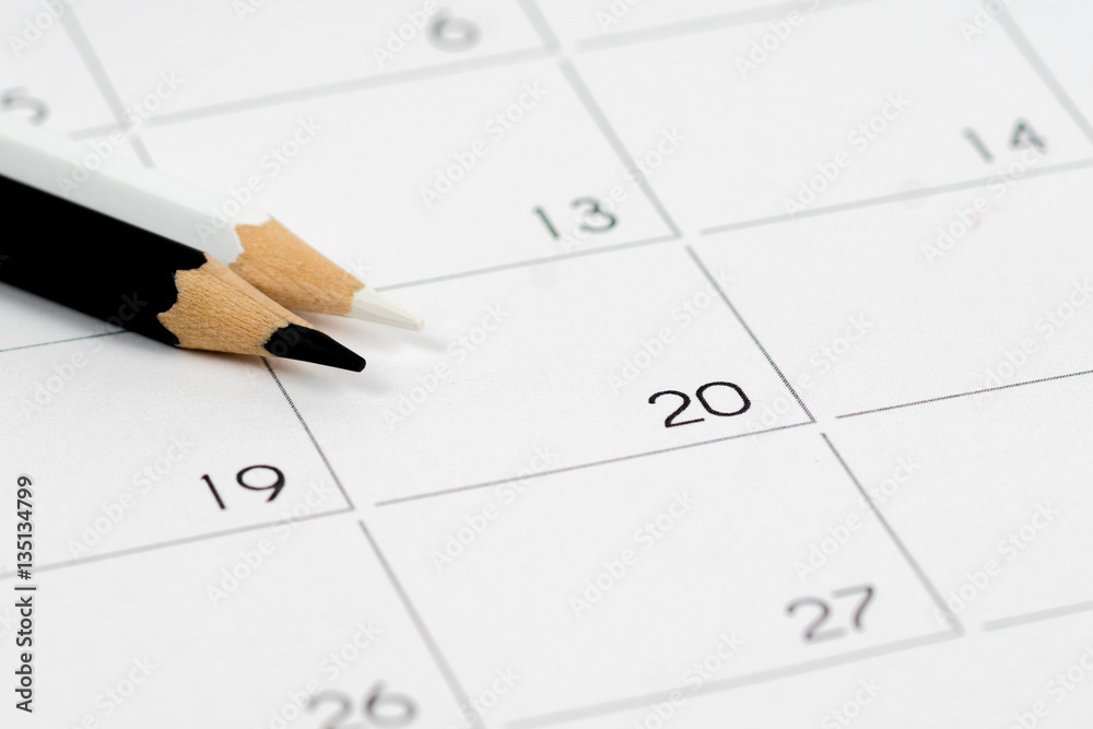 black-n-white pencils on empty calendar grid black-n-white pencils on empty calendar grid