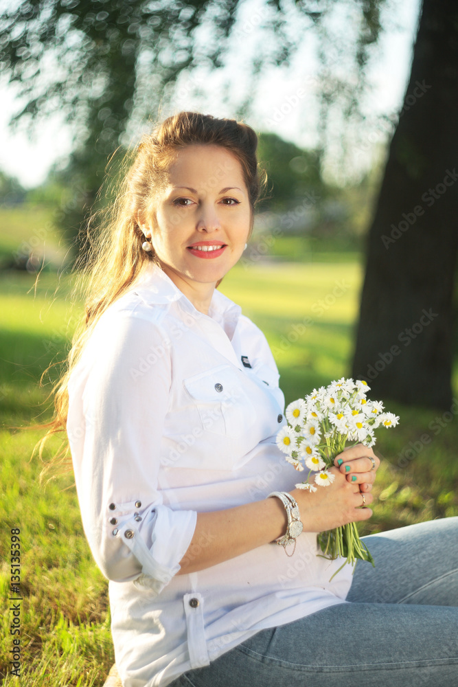 Beautiful pregnant woman relaxing outside in the park Beautiful pregnant woman relaxing outside in the park