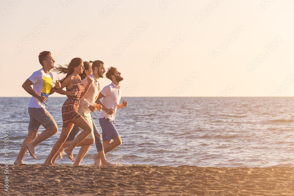 happy young people group have fun white running and jumping on beach at sunset time happy young people group have fun white running and jumping on beach at sunset time