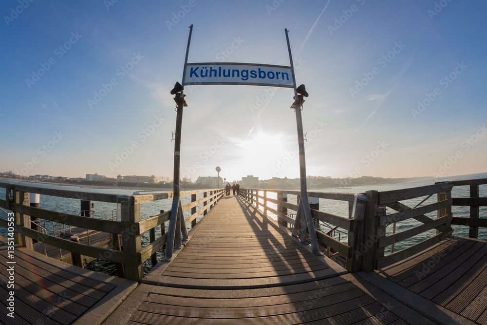 Pier of kuehlungsborn with view of the skyline of the city in the sunset at the baltic sea