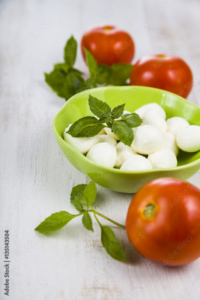 Mozzarella in a green plate on a wooden table. Mozzarella balls Mozzarella in a green plate on a wooden table. Mozzarella balls