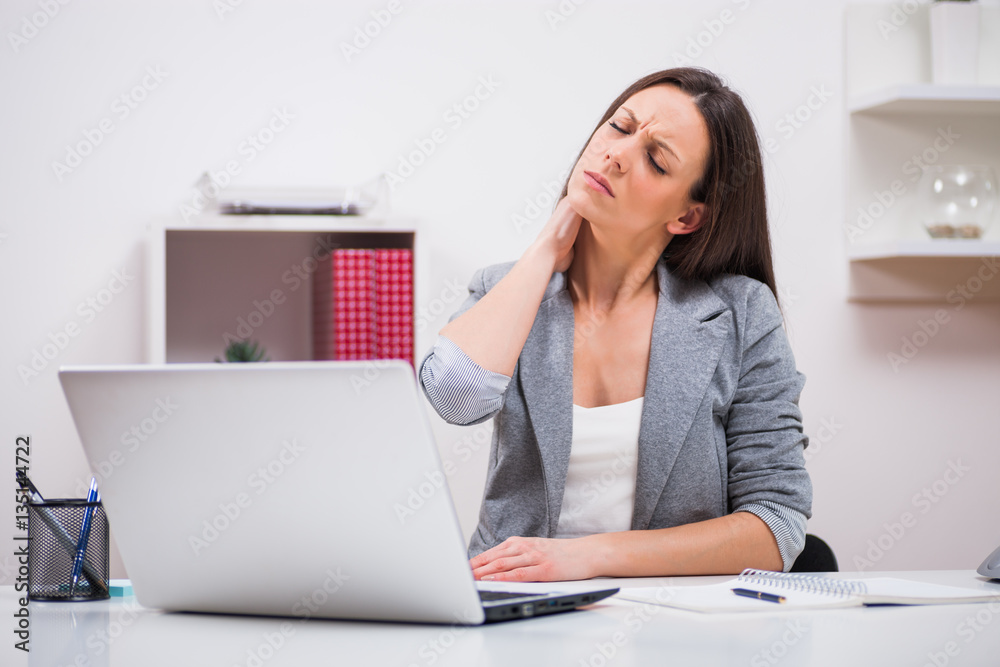 Young businesswoman is having pain in neck at work. Young businesswoman is having pain in neck at work.