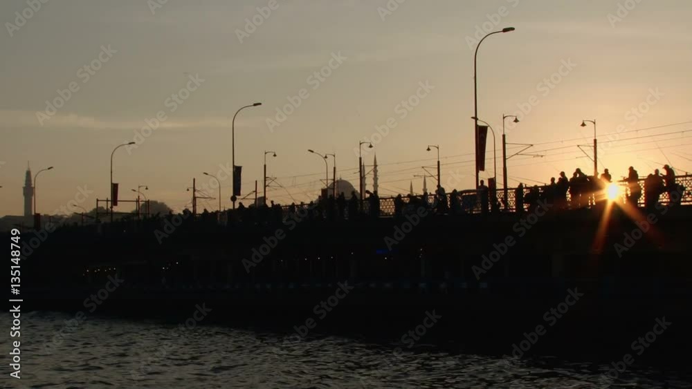 Silhouettes of Turkish fishermen as the sun sets behind the Galata bridge in Istanbul, Turkey Silhouettes of Turkish fishermen as the sun sets behind the Galata bridge in Istanbul, Turkey