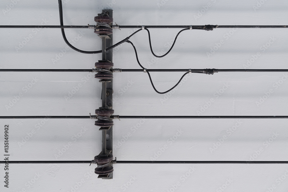 Power line and porcelain insulators with rack on ceiling.