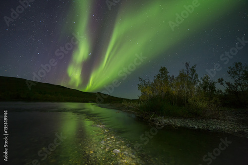 Aurora Borealis over the river. River Paypudyna. Polar Urals. Russia.