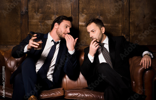 Collusion in business and global conspiracy between two successful businessmen. Rich men spending time in men's club and solving global problems.