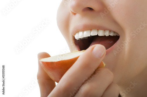 beautiful healthy teeth, the girl bites apple half isolated on white background