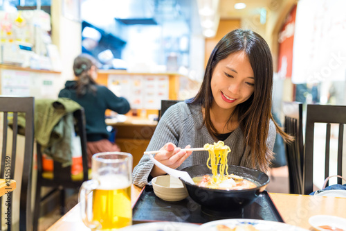 Woman eating ramen in Japanese ramen shop