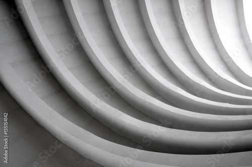 Architectural background. Modern white concrete arched composition in perspective. Semicircular shapes. The light in the end. photo