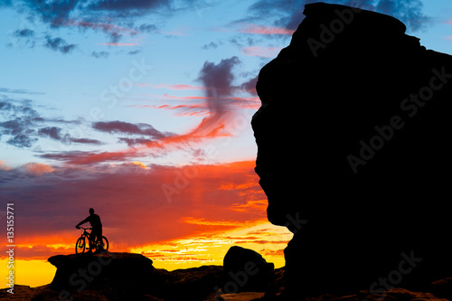 mountain bicycle rider on the hill with sunset background photo