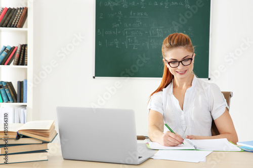 Young teacher at desk in cl...