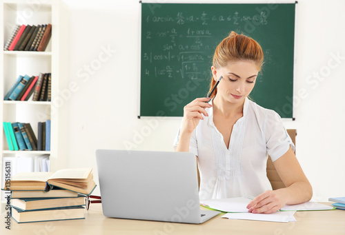 Young teacher at desk in cl...