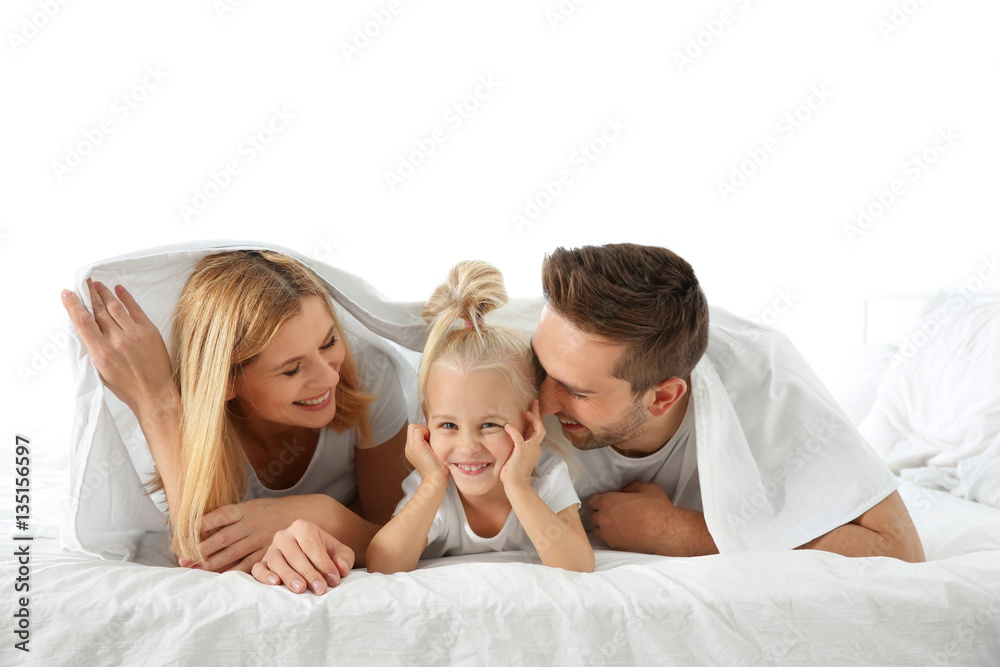 Cute little girl with parents lying on bed under white sheet Cute little girl with parents lying on bed under white sheet