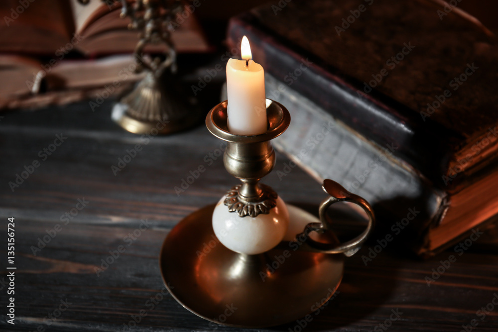 Burning candle and Bible on wooden table Burning candle and Bible on wooden table