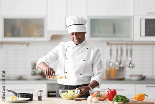 Valokuva Mature Indian chef cooking in kitchen