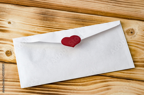 Happy Valentine's Day. Postal envelope with heart on a wooden background. Love. Celebratory background