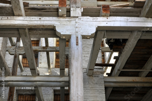 The frame of old industrial building. The wooden columns and beams in the interior.