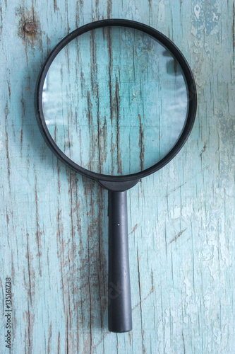 Magnifying glass on blue wooden boards