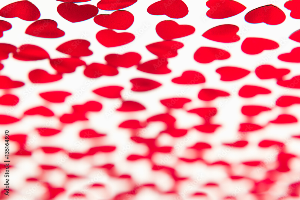 Valentines day pattern of red hearts confetti with blur on white background. Festive Valentine. Valentines day pattern of red hearts confetti with blur on white background. Festive Valentine.