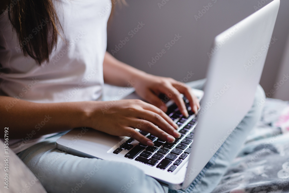 Fototapeta premium Teen girl using laptop in bedroom