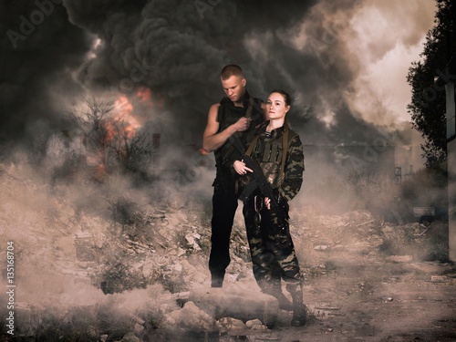 Φωτογραφία girl and man in military camouflage uniforms among the ruins