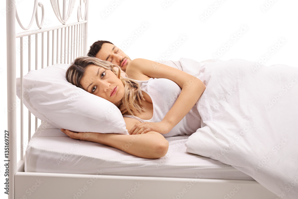 Worried woman lying in bed with a guy