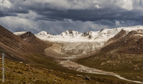 landscape in the mountains, peaks and slopes, storm clouds over