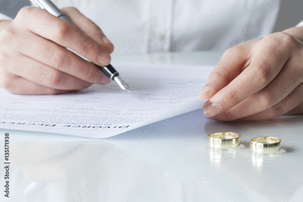 Wife signs divorce decree form with ring Wife signs divorce decree form with ring