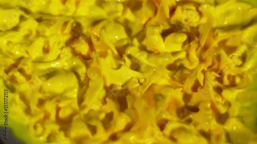 Yellow paint dancing up and down on top of a speaker - overhead shot