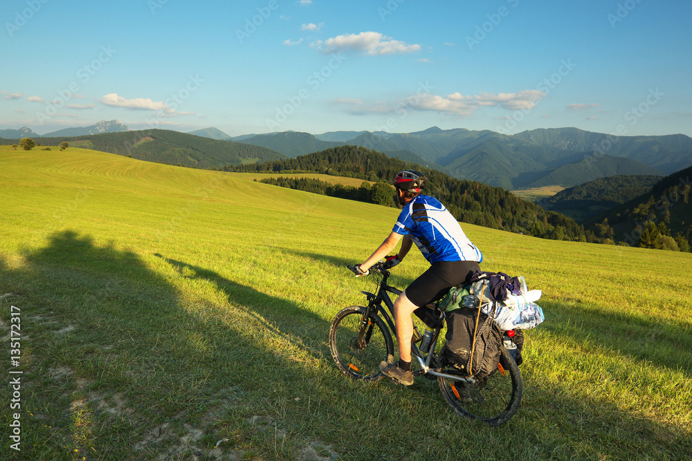 Tourist on bicycle with mountain on background, Slovakia