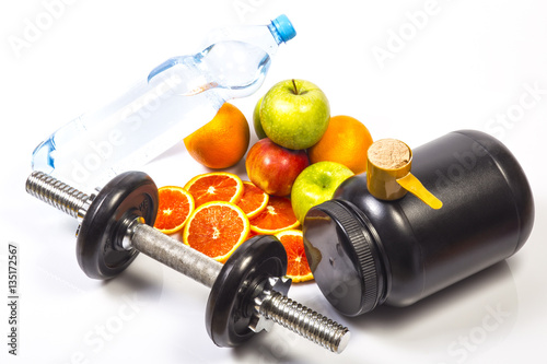 Concept of healthy active lifestyle. red oranges, apples, slices of red orange. Bottle with pure drinking water. Fitness dumbbell. Jar with whey protein with scoop on the jar. White background.