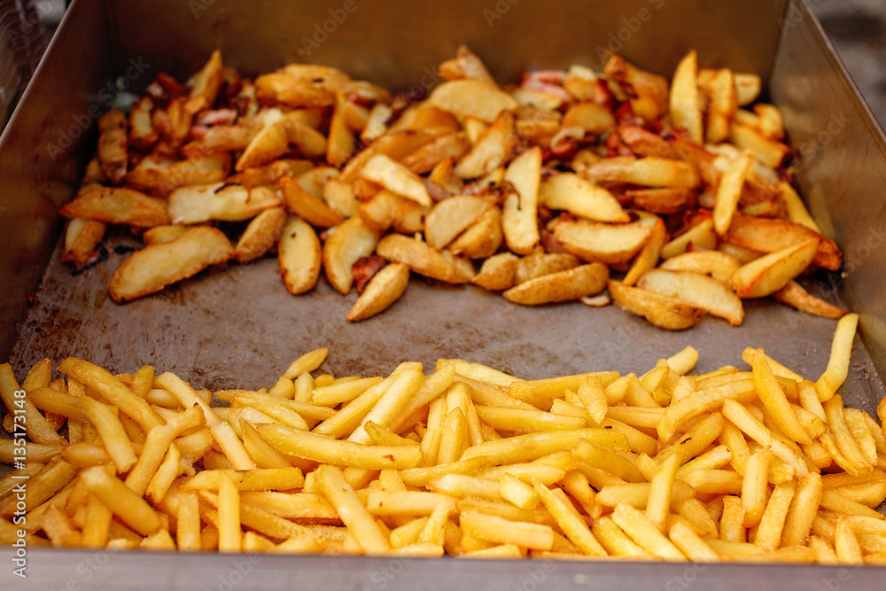 Steel container with roasted potato wedges, french fries Steel container with roasted potato wedges, french fries