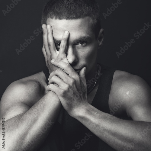 Portrait of handsome fit man in black shirt. Black and white.