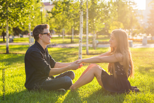 couple in the park sitting on the grass, have a good time together