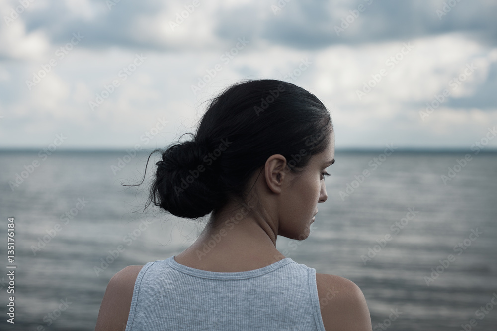 Sensual portrait of young beautiful brunette woman posing against the background of sky and water. Sensual portrait of young beautiful brunette woman posing against the background of sky and water.
