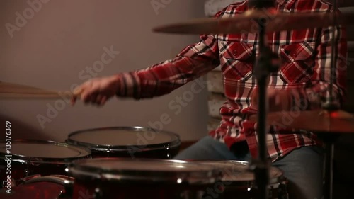 Attractive young man drummer playing on his kit photo