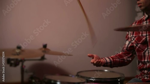 Young hipster drummer juggling drumsticks photo