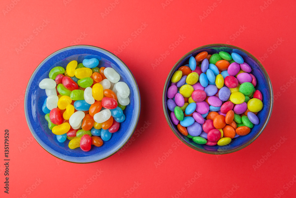 Candy sweets in bowls on red background