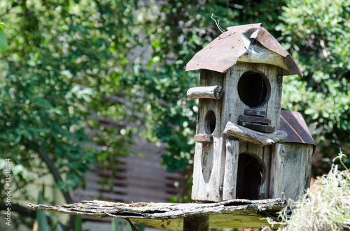 Rustic birdhouse built with sticks and wood and sheet metal