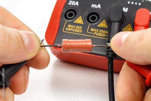 Test the resistor with a multimeter on a white background photo