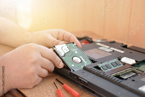 Engineer restores the laptop PC. Installing the hard drive hardware, RAM. Electronic repair shop, technology renovation, business, concept repairs.