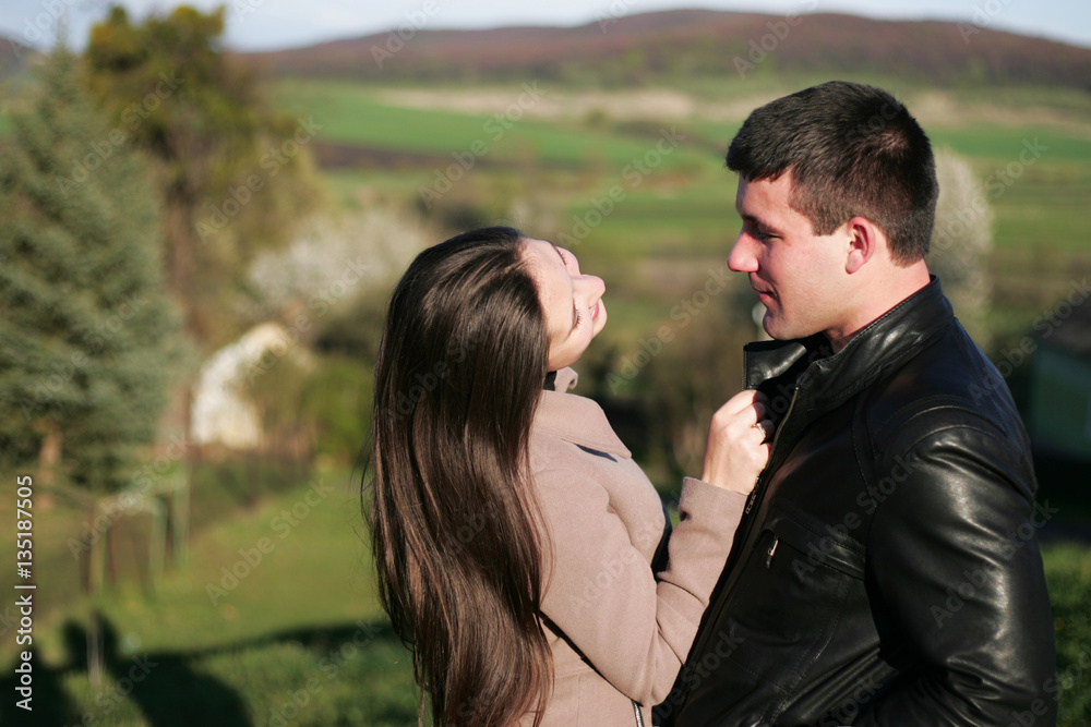 Fototapeta premium Charming and young man and woman standing together in field