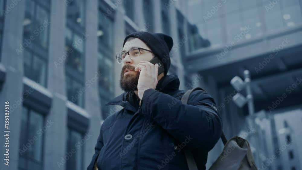Man concentrated talking on phone on business street, conversation near office bulding, bottom view hd Man concentrated talking on phone on business street, conversation near office bulding, bottom view hd