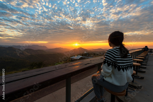 People sit on the wooden table and see Sunrise in the morning.