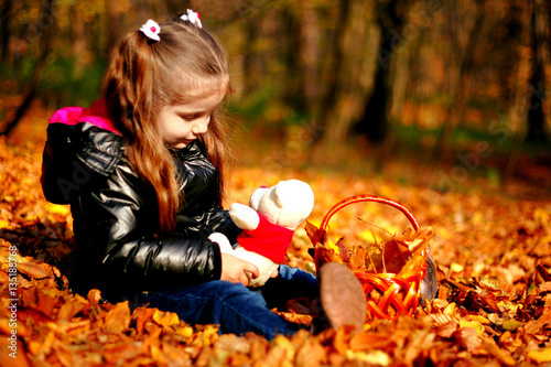 Cute baby sitting on leaves in the park