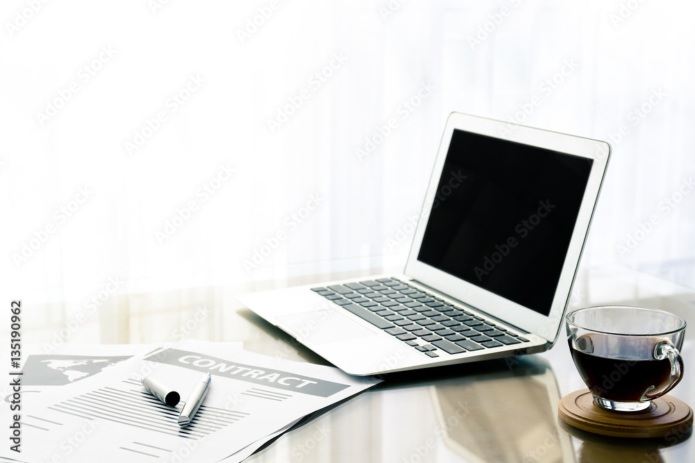 Office workplace with laptop and document on wood table in the morning with black coffee Office workplace with laptop and document on wood table in the morning with black coffee